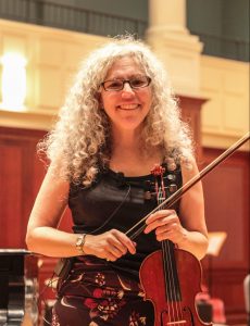 Alicia Svigals posing with violin and bow