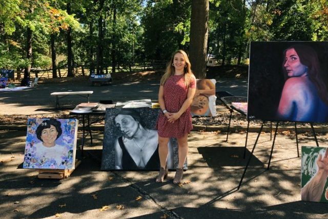 Halle Luttrell in front of some art pieces at her open-air art gallery.