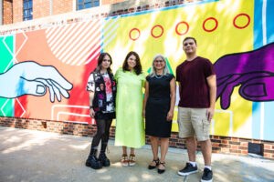 a group of people standing in front of a mural